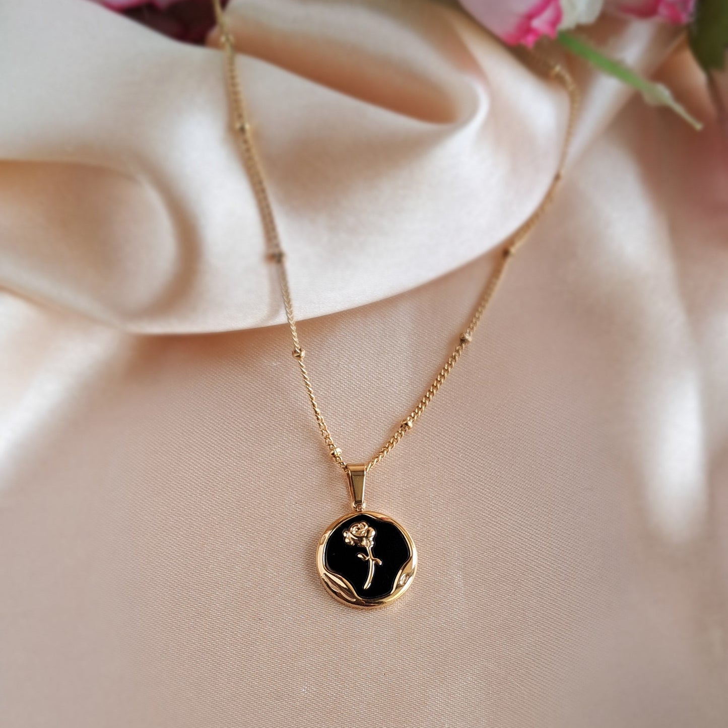 Close-up of golden rose necklace chain and pendant