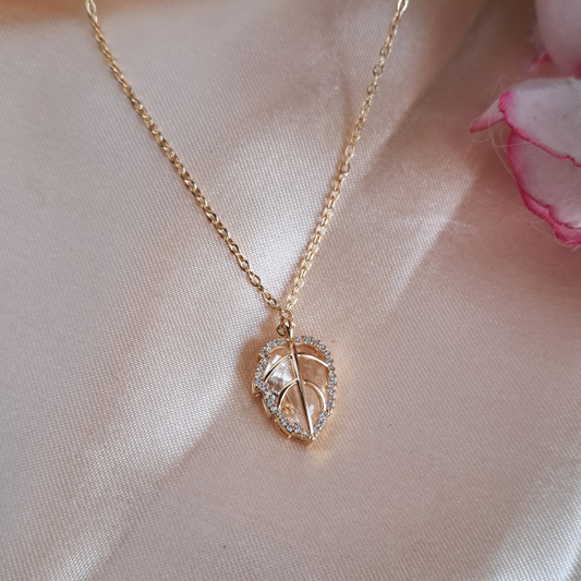 Crystal necklace with golden leaf cage pendant