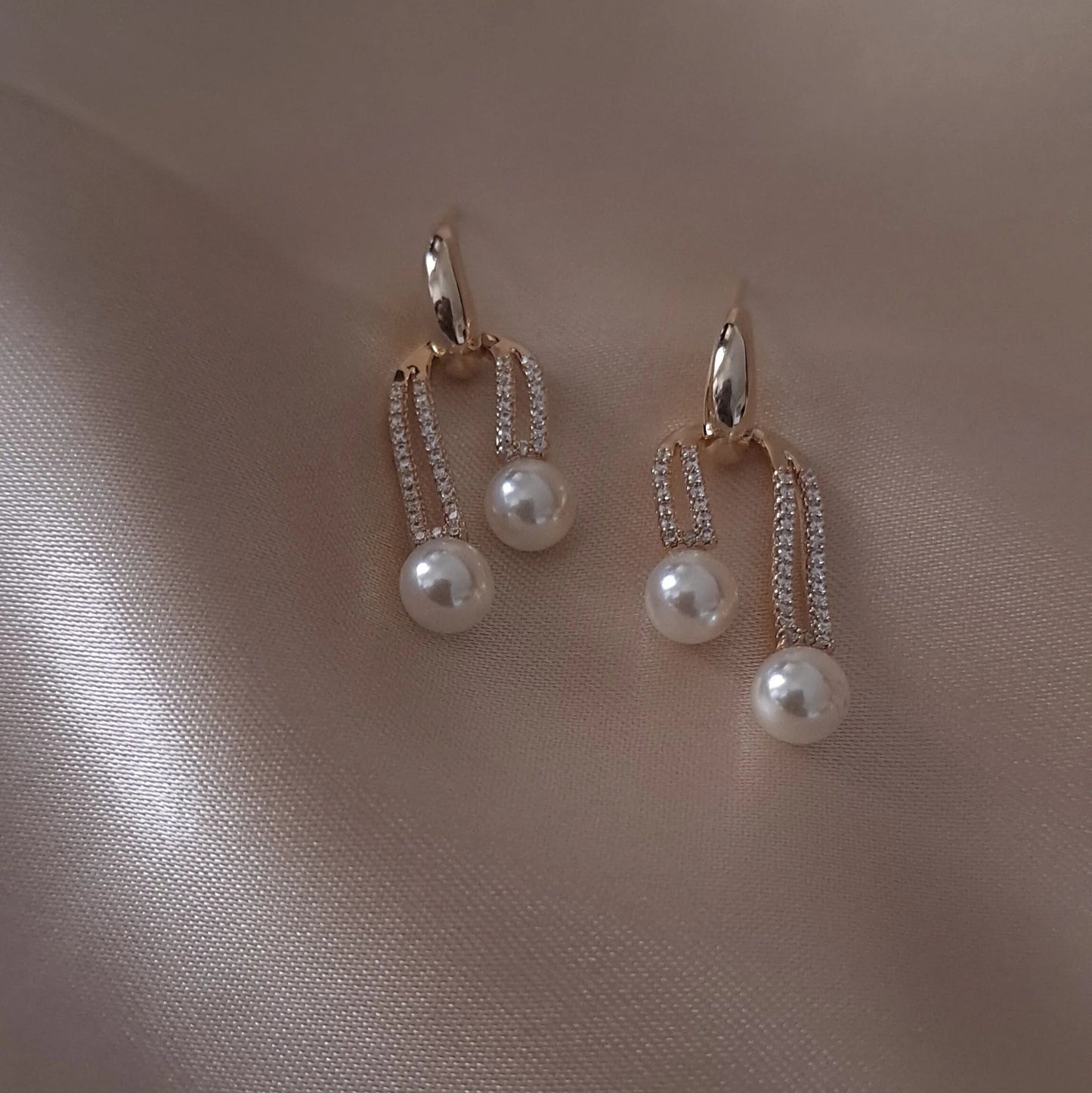 Golden stone studded earrings with pearl drops in elegant pattern